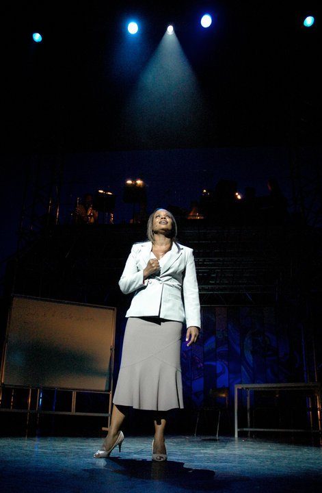 Marcia Richards on stage under a spotlight